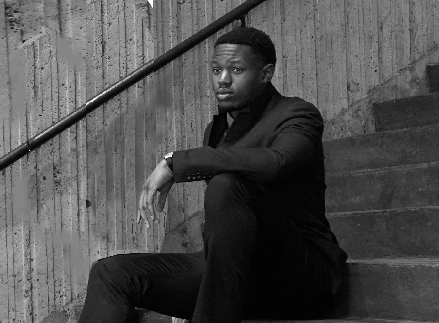Mambay Kanu seated on a concrete staircase